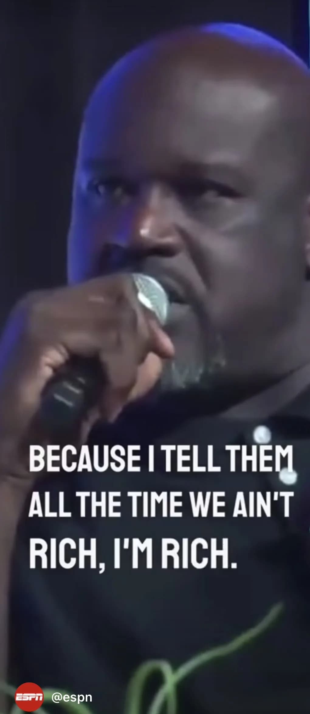 Still from an ESPN clip of Shaquille O’Neal speaking into a microphone, with the on-screen caption: Because I tell them all the time we ain’t rich, I’m rich.